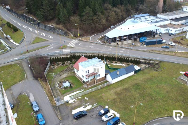 A family house on SNP Street in Považská Bystrica, surrounded by green areas and an intersection.