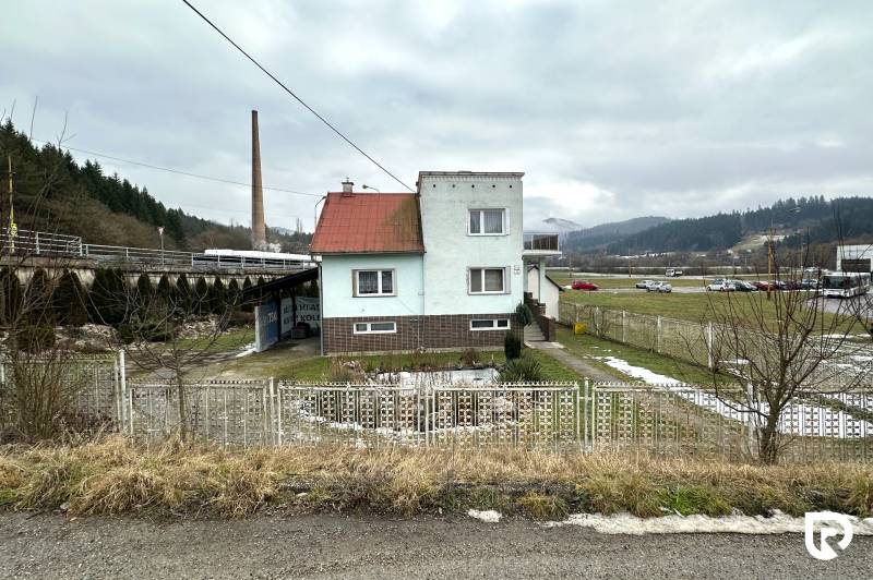 A family house on SNP Street in Považská Bystrica, with a garden and a fence in front of it.