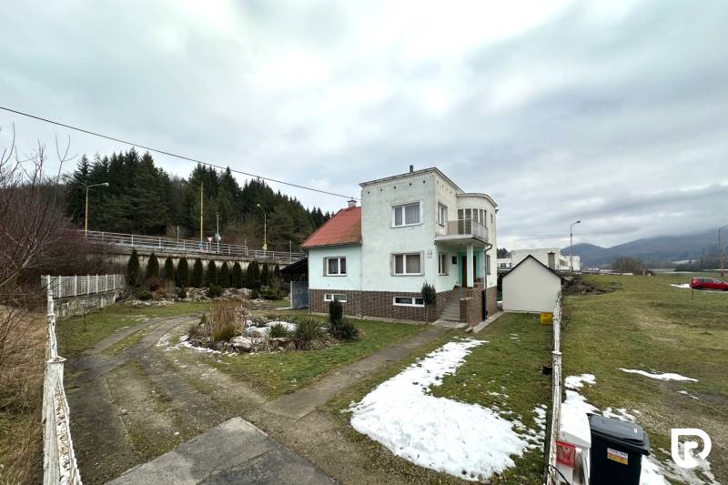 A family house on SNP Street in Považská Bystrica surrounded by a snowy garden and a driveway.