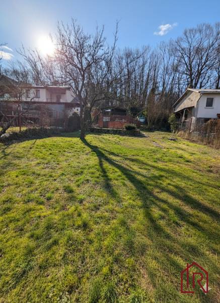 Sunny plot in Šemša near a cottage with a grassy area and a tree.