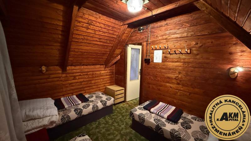 Interior of a cabin with wooden paneling, beds, and a chandelier, a cozy environment for relaxation.