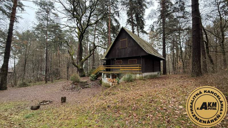 A cabin in the woods with wooden elements near Kováčová, surrounded by trees and nature.