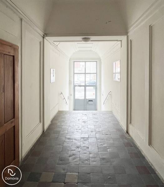 A corridor with tiles and white walls leads to a glass door on Vajnorská Street.