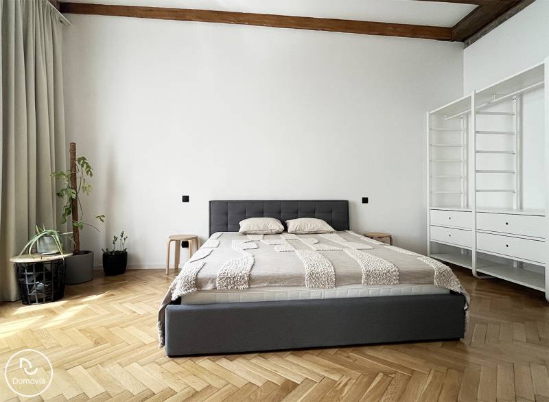 Stylish bedroom with a bed in a 2-room apartment, plants, and storage space on Vajnorská Street.