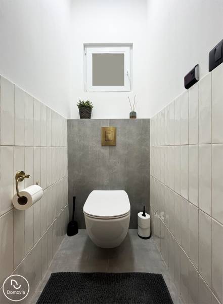 Bathroom with toilet, white and gray tiles, light saturation, subtle details on Vajnorská street.
