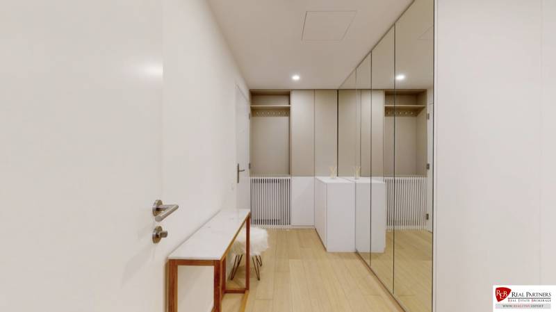 An entrance hall with a wooden decor floor and large mirrors in a 3-room apartment.
