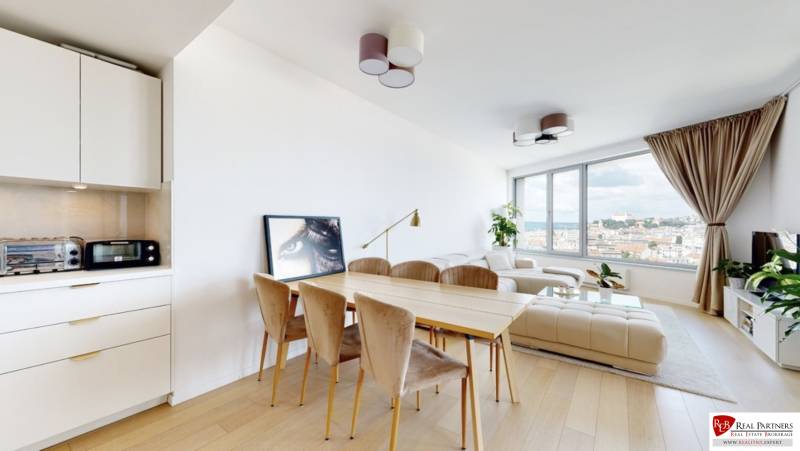 A bright living room with a dining table, a white sofa, and a view, 3-room apartment.