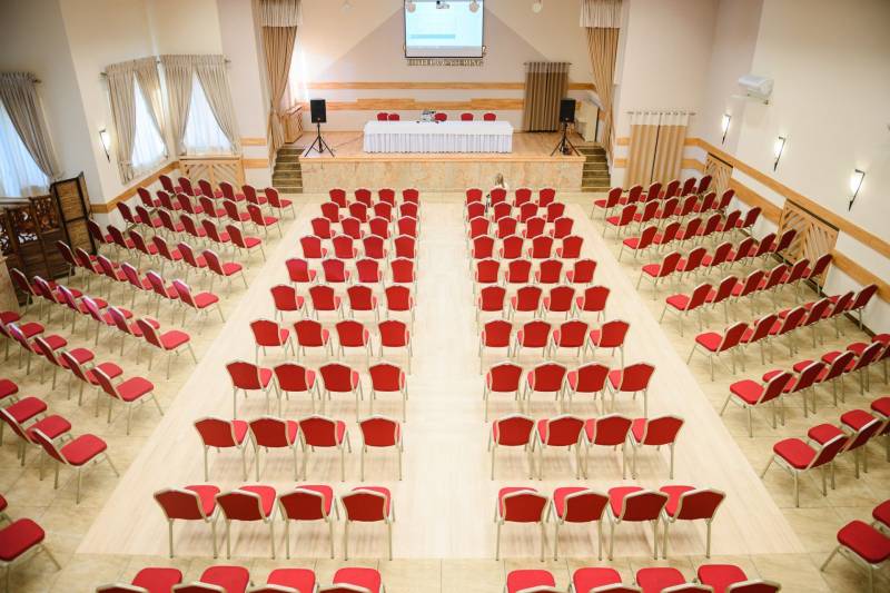 Conference room with red chairs and wood-patterned flooring in hotels and guesthouses.
