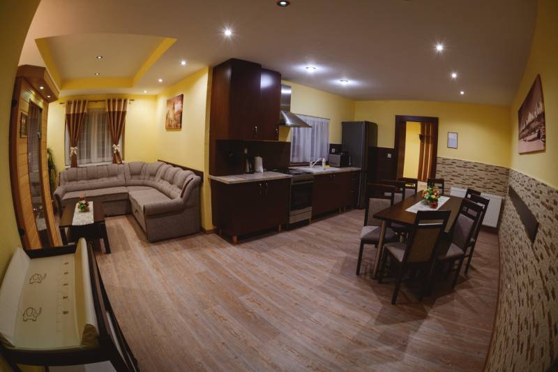 Kitchen and living room Hotels and guesthouses with a corner sofa and wooden decor flooring.