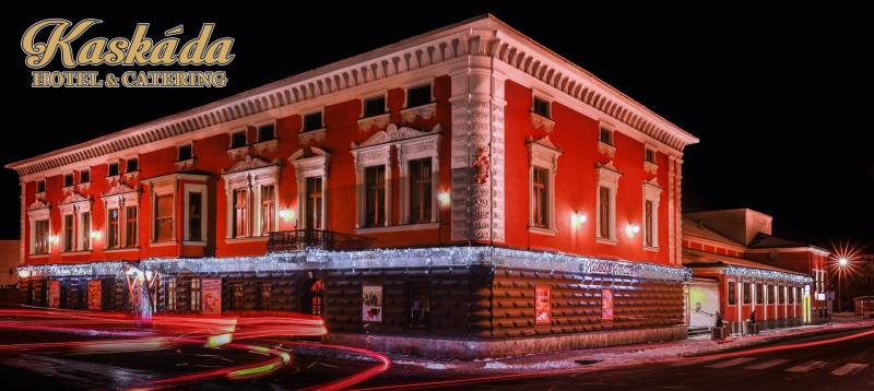 A brightly lit hotel building with a red facade in Poprad. Hotels and guesthouses.