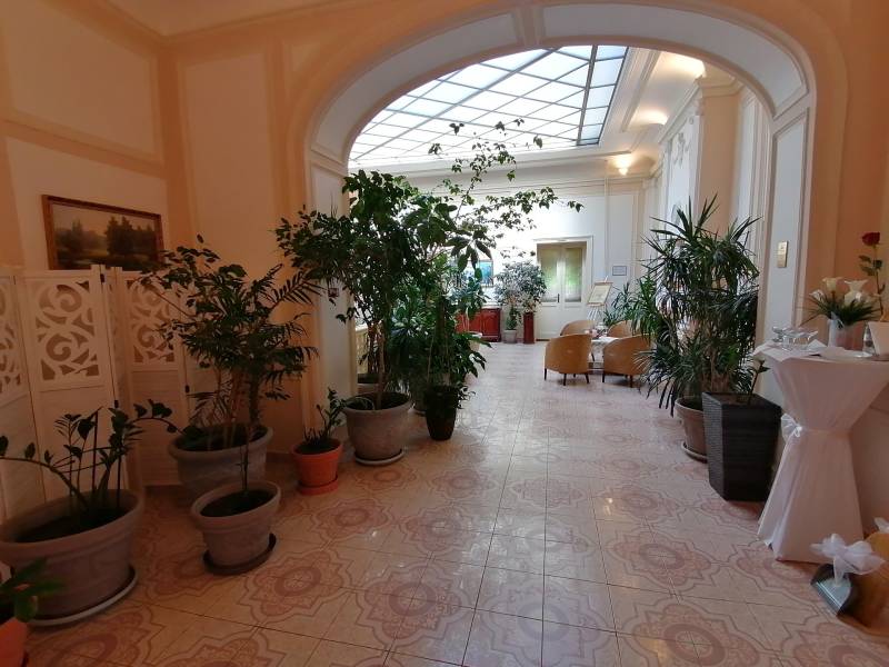 A corridor in hotels and guesthouses with flowers and seating, floor with decor.