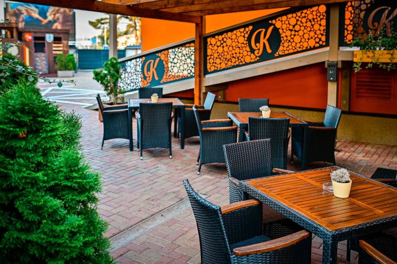 Outdoor seating in Poprad, surrounded by greenery, hotels and guesthouses.