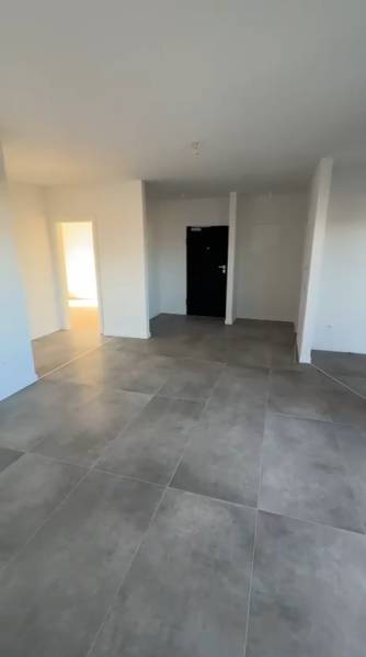 Interior of a 3-room apartment with large tiles and white walls.