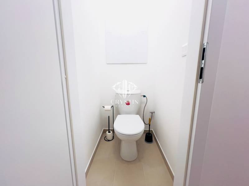 A bathroom with white walls in a two-room apartment, simple sanitary equipment.