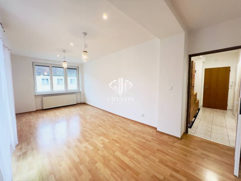 A room in a 2-room apartment with a wooden decor floor, lighting fixtures, and a built-in window.