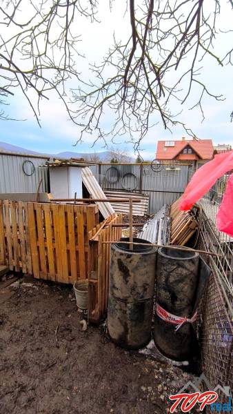 Plots - housing on Mierová Street in Krásnohorské Podhradie with materials and barrels.