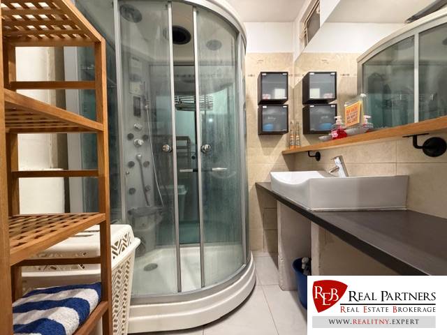 Bathroom with a shower and a sink with a wooden decor, 3-room apartment.