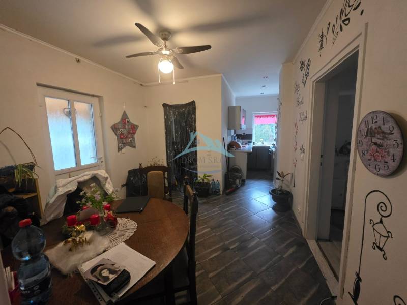 The dining room of a family house with a ceiling fan and decorative wall decorations.