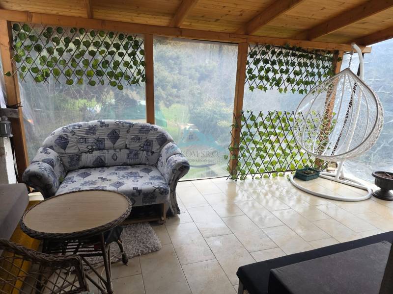 A family house with a spacious terrace, a comfortable couch, and a swing in the town of Hont.