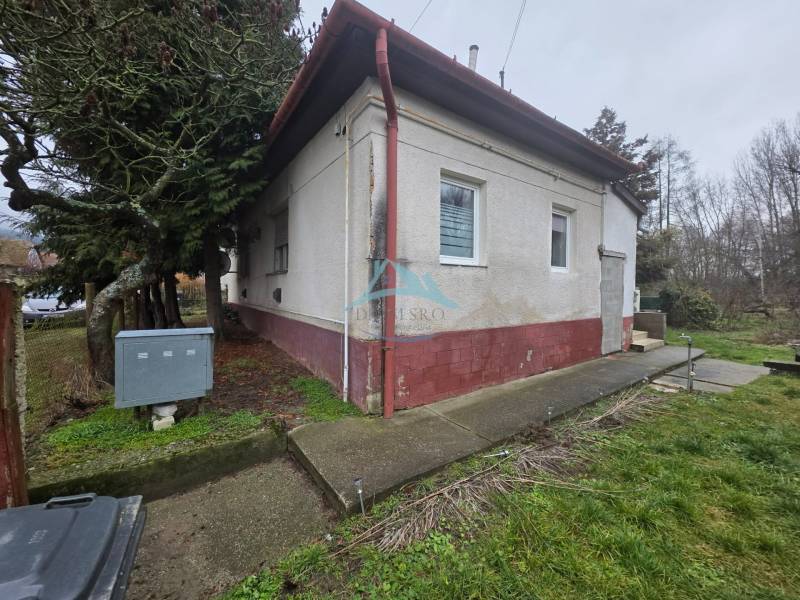 The family house in Hont has a white facade, windows with bars, and entrance stairs.