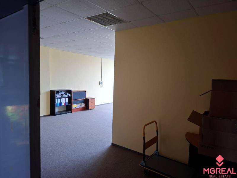 Offices with dark carpet, shelves, and boxes, suitable for rent.