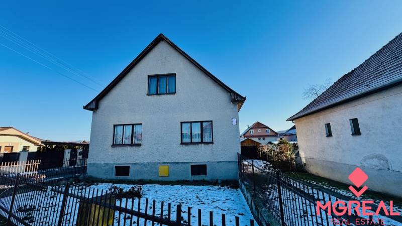 A family house on Veľké Bielice Street in Partizánske with a fenced garden, snowy yard.