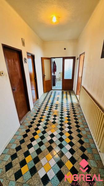 A hallway in a family house with a colorful geometric pattern on the floor.