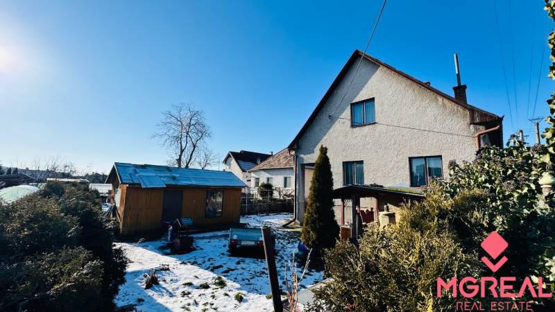 Pitched roof, adjacent shed, and snow-covered garden at a family house in Partizánske, in Veľké Bielice.