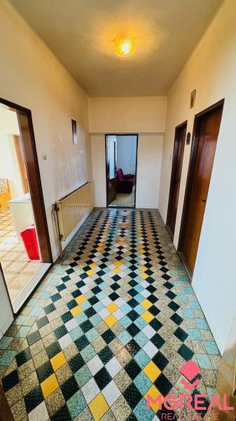 A hallway with colorful tiles in a family house with wooden doors and a radiator.