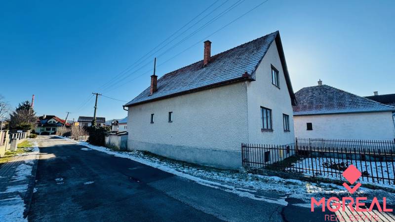 A family house on Veľké Bielice Street in Partizánske, next to the road, with a snow-covered garden.