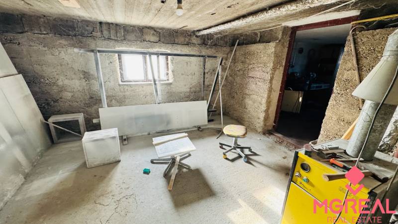 A basement space in a family house with simple furniture and a window.