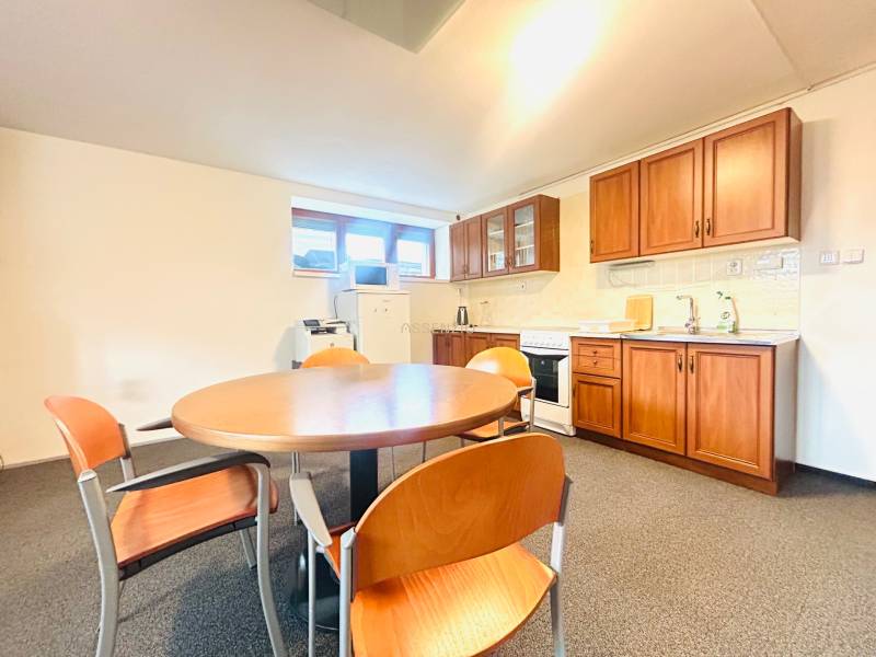 A kitchen in a family house with a dining table, chairs, and a kitchen unit with a wooden decor.
