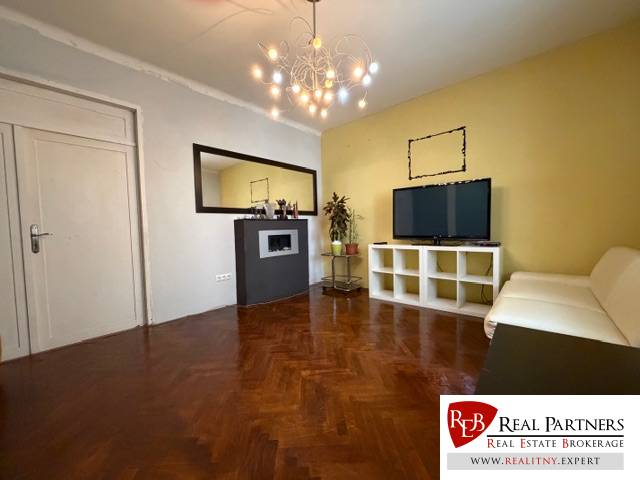A living room with a wood-patterned floor in a 5 or more room apartment.
