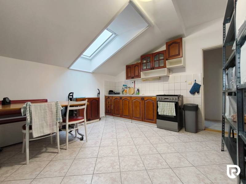 A bright kitchen in a family house with wooden cabinets and a skylight.