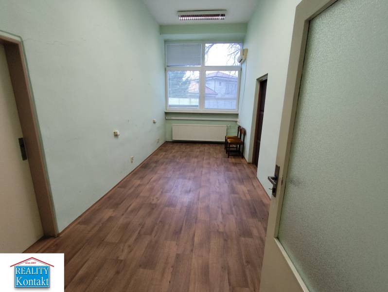 Offices with wood-patterned flooring and a large window available for rent.