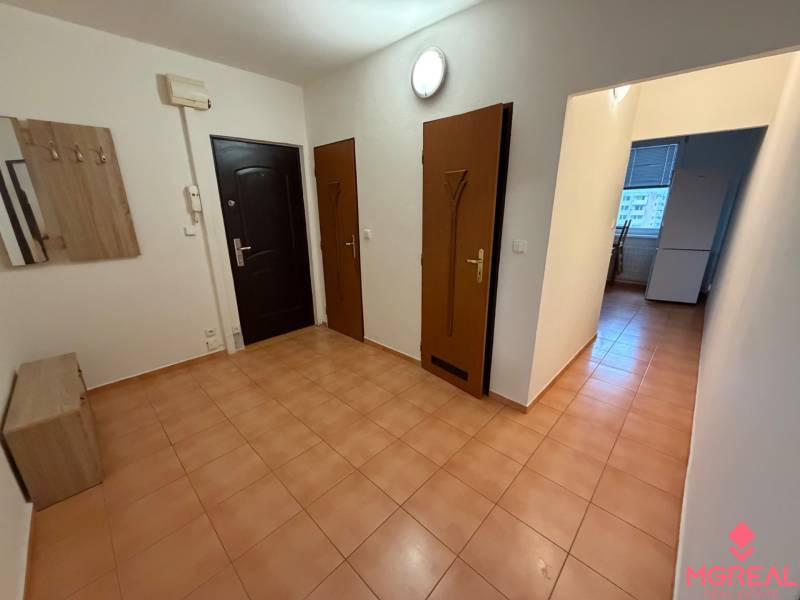 Entrance hall in a 3-room apartment with tiles and furniture in wooden decor.