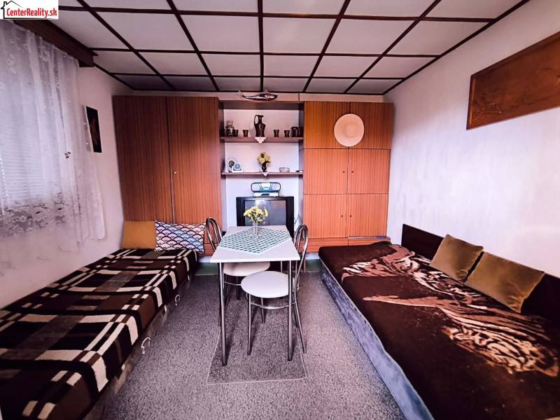 Interior of a cabin with beds, a table, cabinets, and decorations.