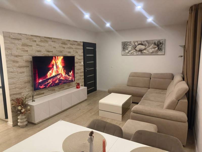 Living room in a 3-room apartment with a corner sofa and a wooden decor floor.