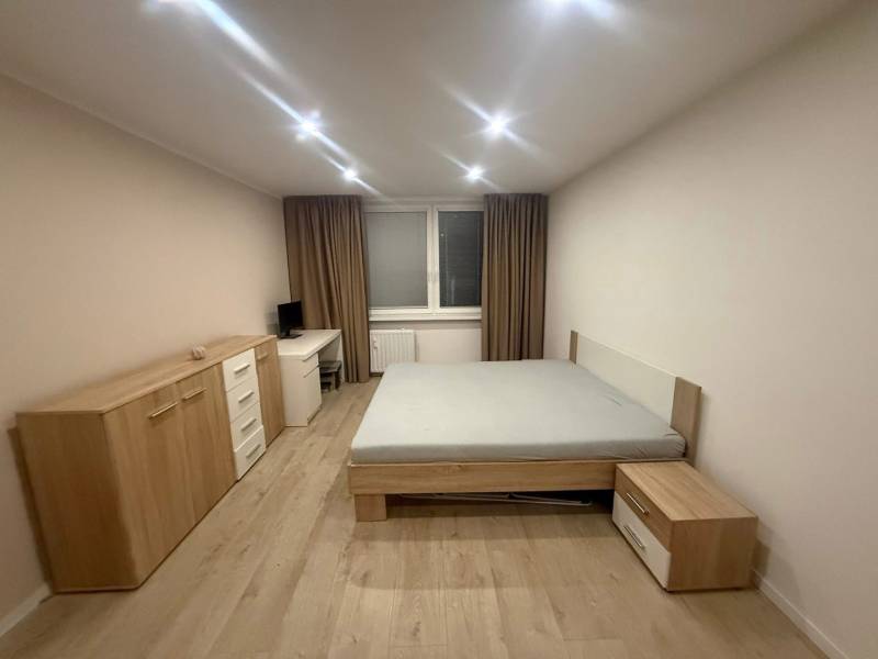 A bedroom in a 3-room apartment with a bed and furniture, floor with wooden decor.