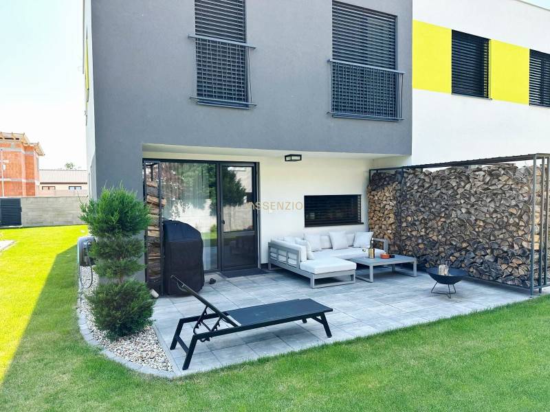 A family house in Rovinka with a terrace, garden, wooden cladding, and outdoor seating.