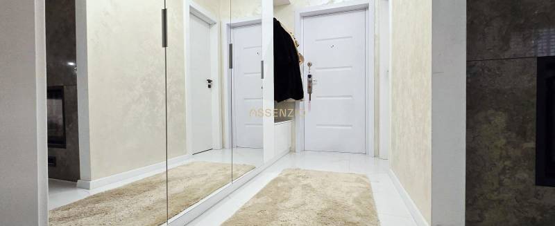 Hallway in a family house with white doors, a mirror, and a soft carpet.