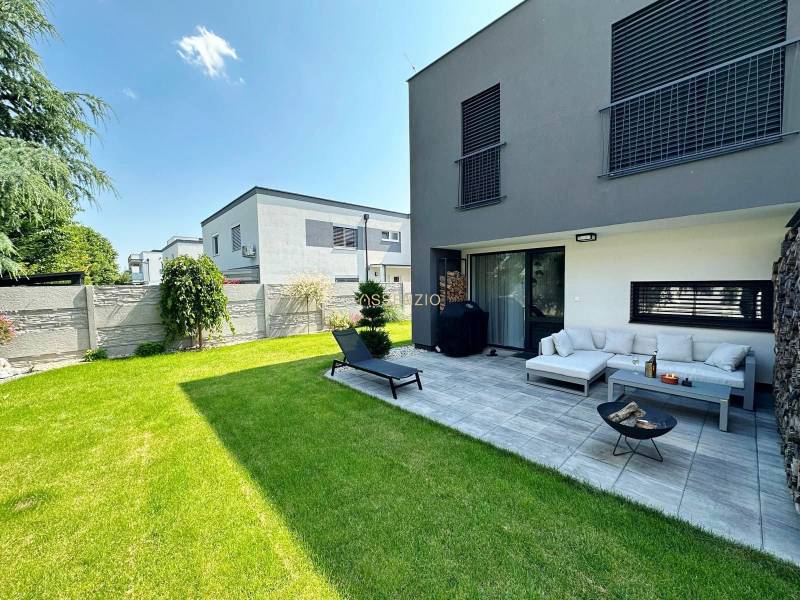 A family house in Rovinka with a terrace, green lawn, and outdoor seating.