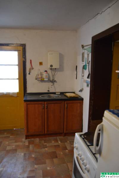 A kitchen in a family house with wooden cabinets and a wooden decor floor.