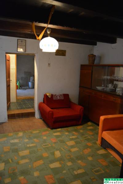 Living room in a family house with a red armchair and a cabinet with dishes.