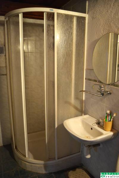 Bathroom in a family house with a corner shower and a sink.