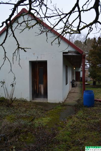 A family house in Abrahám with a courtyard, a blue barrel, and wooden doors.