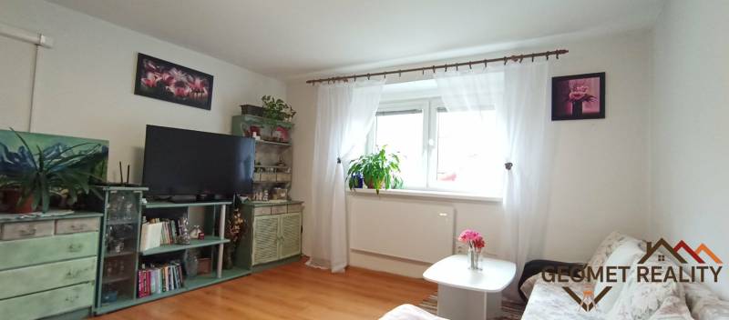 Living room in a family house with wooden floor decor and floral decorations.