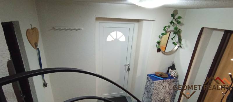 Entrance to a family house with white doors, a mirror, and decorative elements.