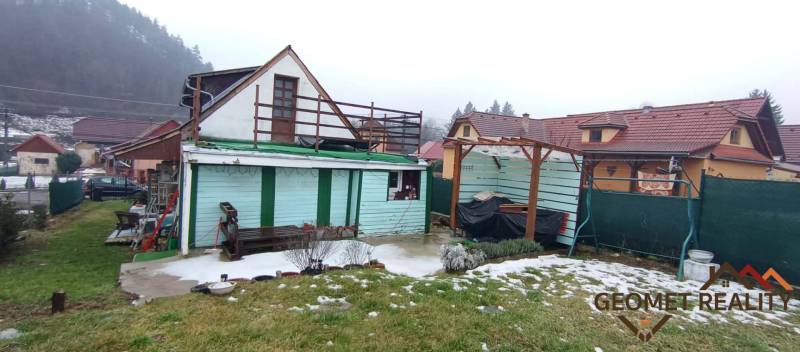 Family house on Cintorínska in Divín with a shelter in the yard and a snow-covered lawn.