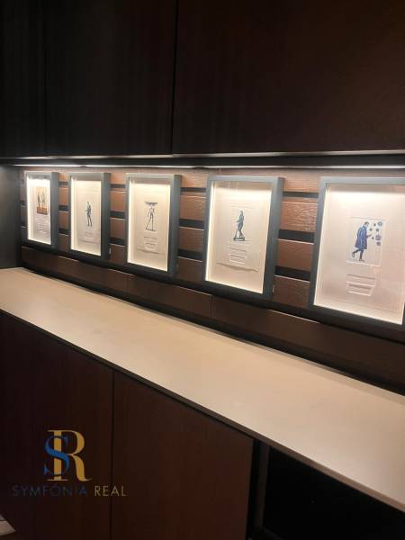 Framed pictures on a wooden shelf wall in a two-room apartment.